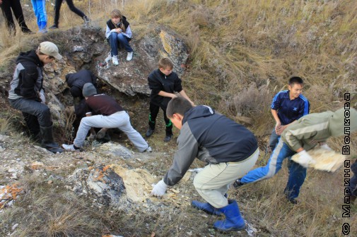 Школьники убирают камни от входа в пещеру