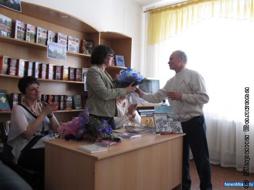 Поэт Александр Петров вручает цветы гостям