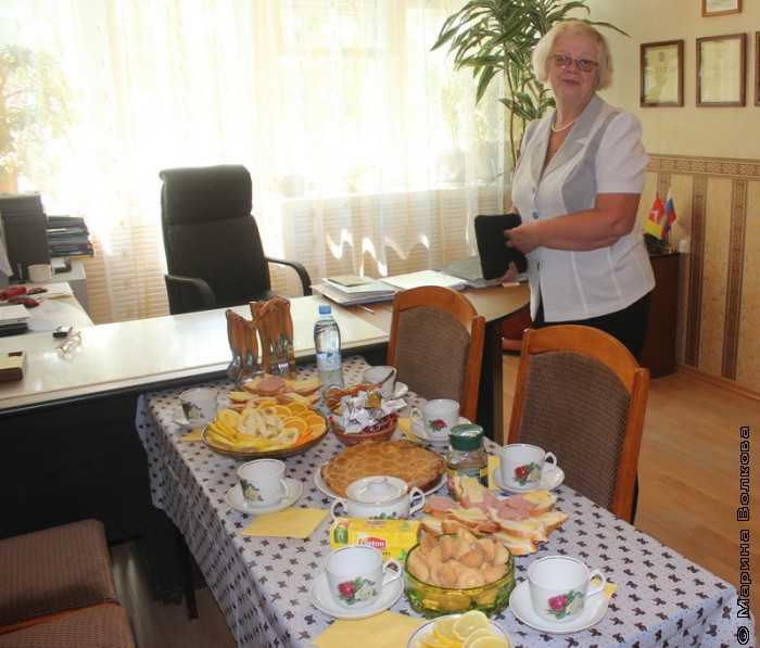 Наталья Шмидт у стола с угощением