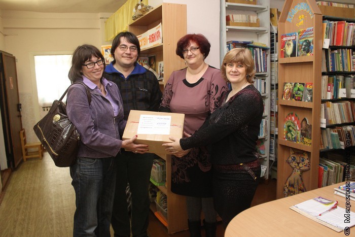 Елена Соловьева передает коробку со своими книгам библиотекарям Копейска